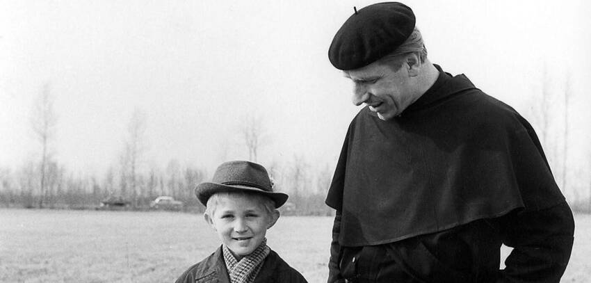 ritratto fotografico di Padre Turoldo con un bambino