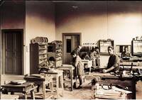 Fotografia in banco e nero: Luigi Mozzani all'interno della liuteria con i propri dipendenti al lavoro (ca. 1942-1943)