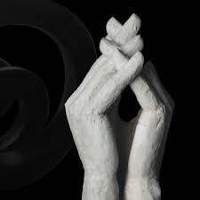 immagine che riproduce l'opera esposta, due grandi mani giunte