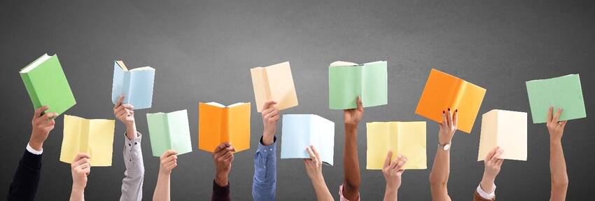 mani che alzano dei libri aperti