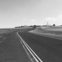 particolare della copertina del libro di Abram Tomasi "Oltre": foto bn con strada americana che corre tra i campi coltivati