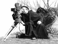 ritratto fotografico b/n di Turoldo con cinepresa