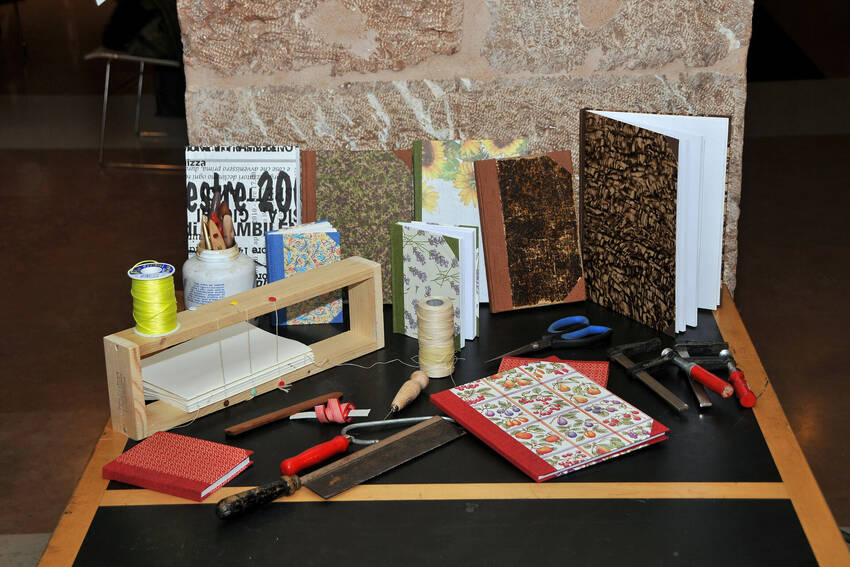 Libri rilegati a mano, morsetti, seghetto, torchio e attrezzatura varia per la rilegatura artigianale (Foto Florio Badocchi 2012)