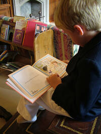 bimbo biondo che legge in biblioteca