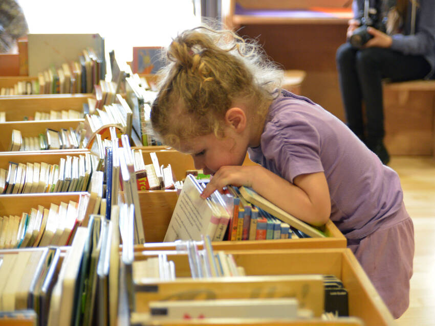 zona bambini - bimba che cerca tra i libri (foto Florio Badocchi 2014)